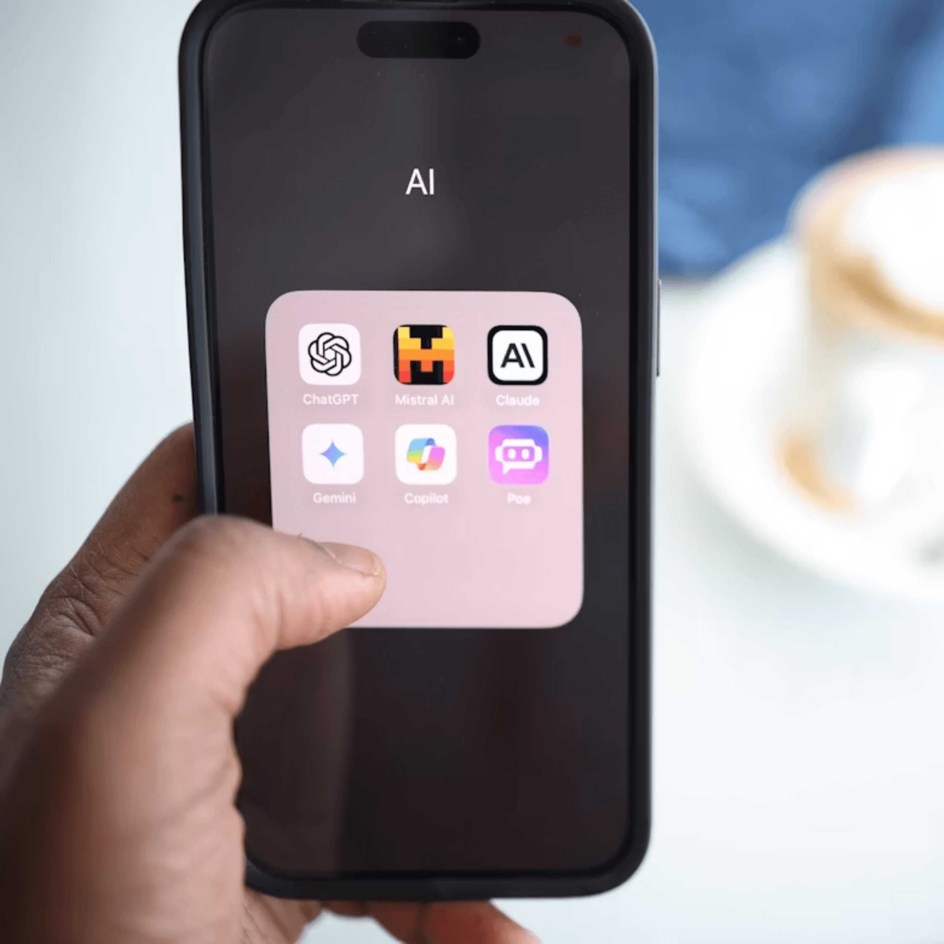Hand houdt telefoon vast met op scherm verschillende AI apps